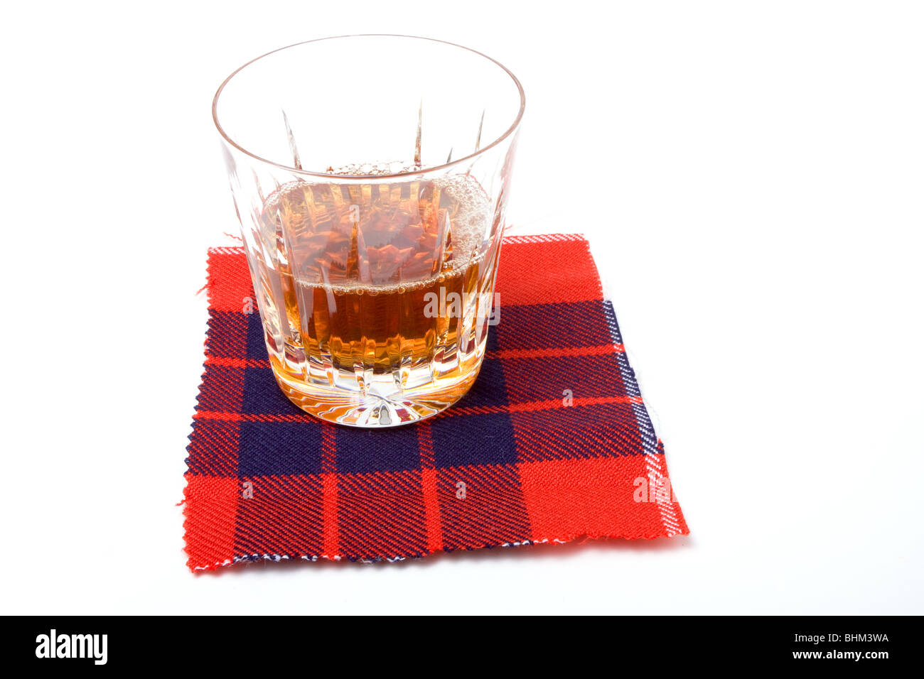 Scottish Malt Whiskey in vetro cristallo in appoggio sulle montagne russe di tartan. Foto Stock