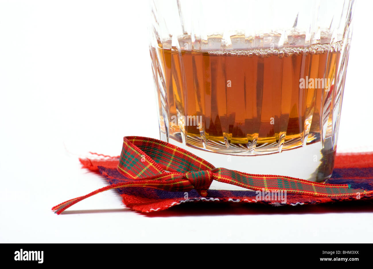 Scottish Malt Whiskey in vetro cristallo in appoggio sulle montagne russe di tartan. Foto Stock