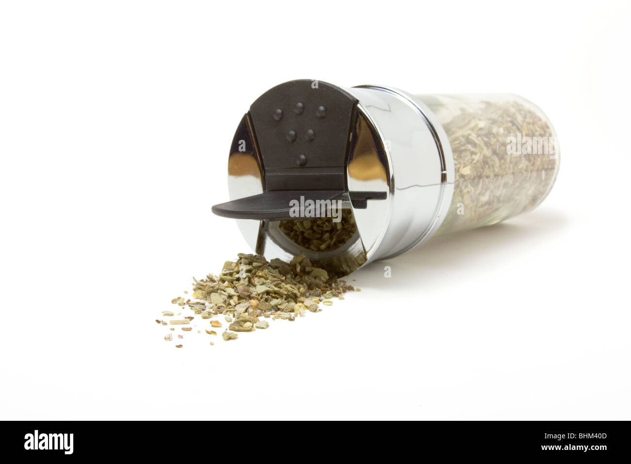 Essiccata la salvia fuoriuscita dal dispensatore di vetro isolata contro uno sfondo bianco. Foto Stock