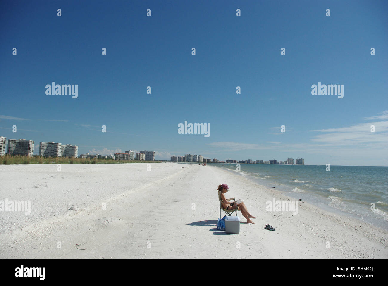 La donna a prendere il sole e la lettura di libro a Tiger spiaggia di coda (Marco Island, Florida, STATI UNITI D'AMERICA) Foto Stock