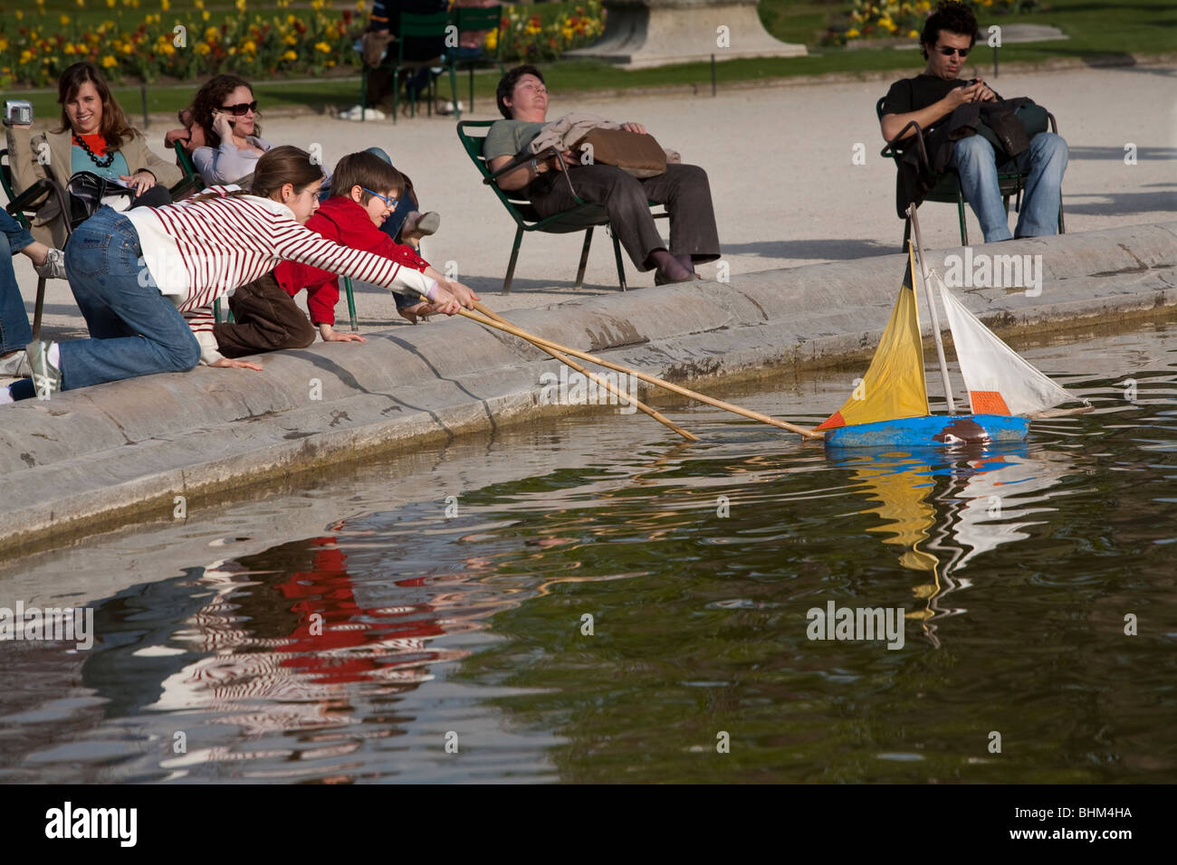 Bambini che giocano con il giocattolo in barca a vela, Giardino delle Tuileries, Parigi, Francia Foto Stock