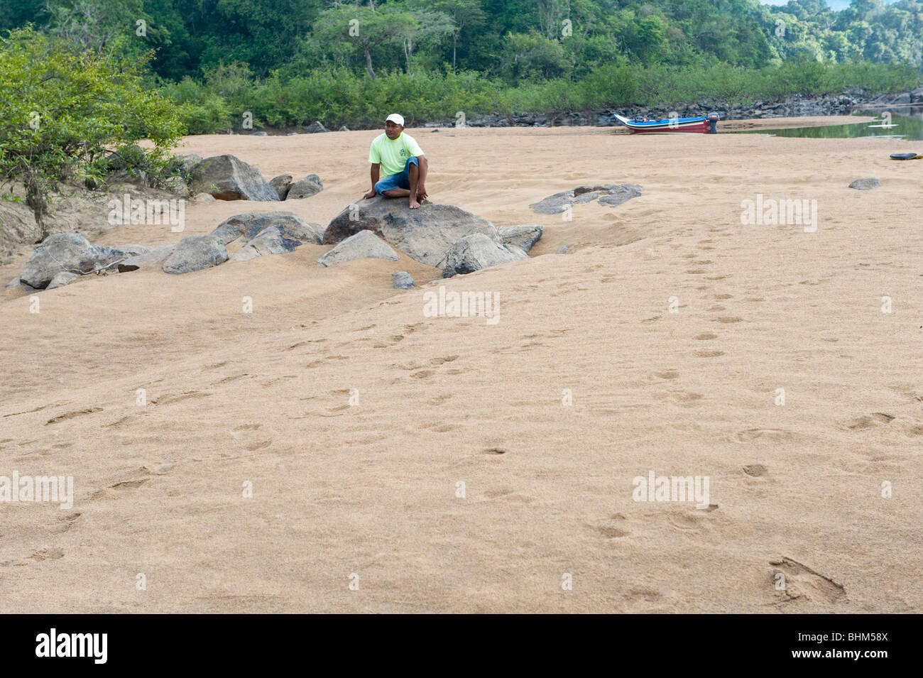 Neville Mosè, Macushi, poggiante sulla roccia di fiume Essequibo Iwokrama Foresta Pluviale scudo della Guiana Guyana Sud America Ottobre Foto Stock