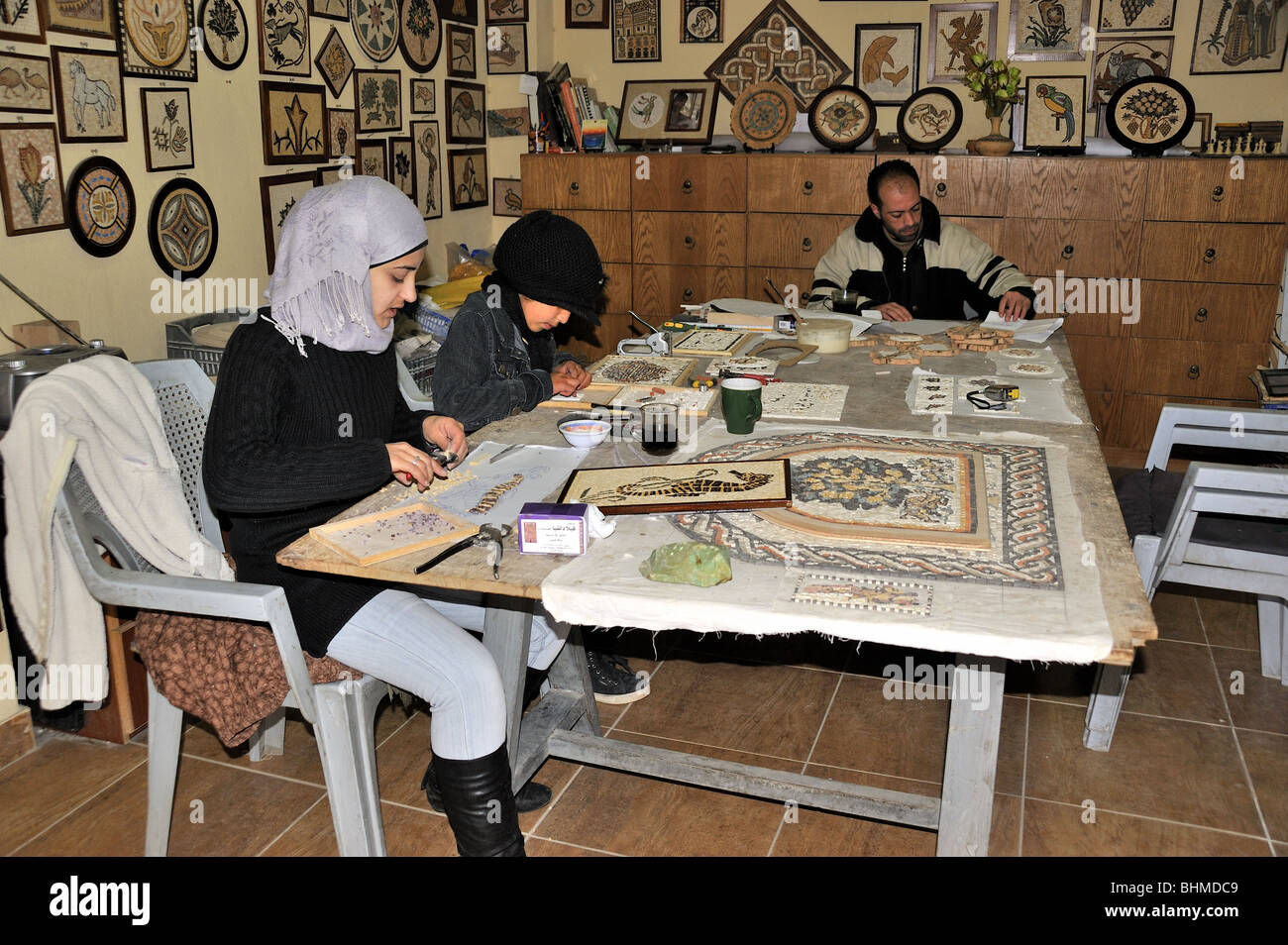 Una famiglia rendendo mosaico nel loro negozio a Madaba city,Giordania Foto Stock