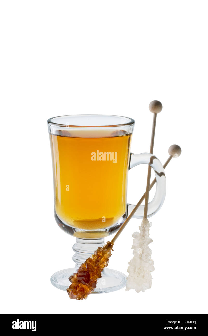 Tazza di tè con Dolce caramello zucchero su bastoni di legno isolato su bianco con tracciato di ritaglio Foto Stock
