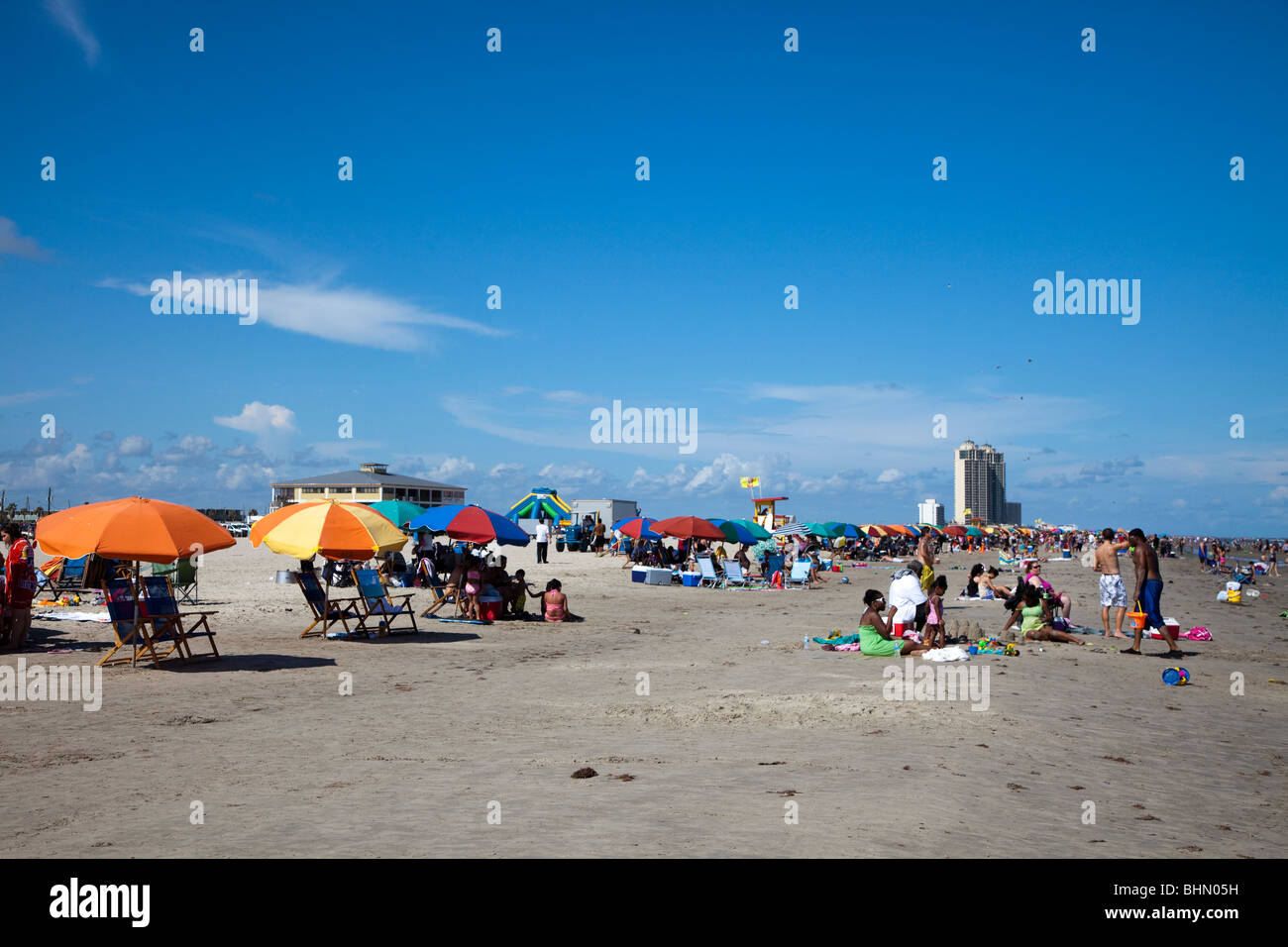 Persone su Stewart spiaggia con ombrelloni e sedie a sdraio Galveston Texas USA Foto Stock