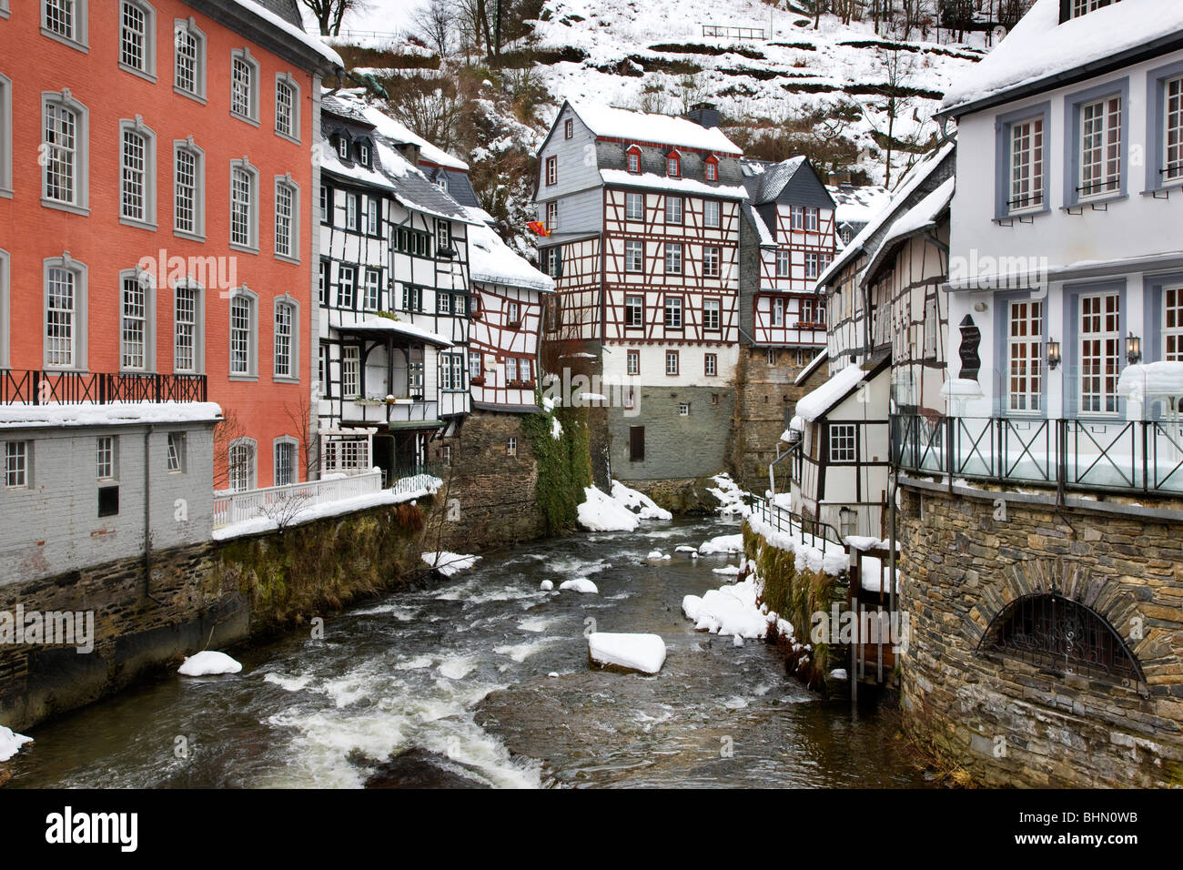A struttura mista in legno e muratura case storiche lungo il fiume Rur a Monschau nella neve in inverno, Eifel, nella Renania settentrionale-Vestfalia, Germania Foto Stock