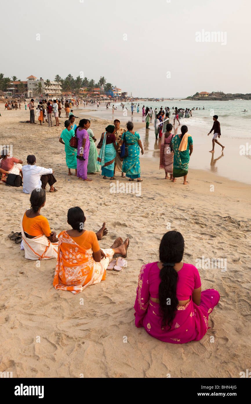 India Kerala, Kovalam, Hawah (EVE) spiaggia, turisti indiano seduto sulla spiaggia Foto Stock