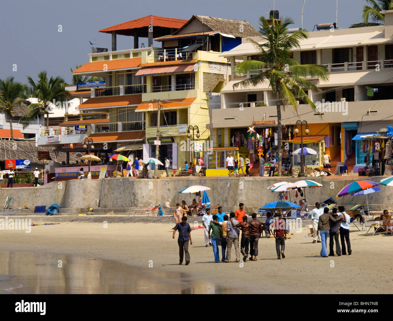 India Kerala, Kovalam, Faro (ADAM) spiaggia, gruppo di Indiani gli uomini guardando western lucertole da mare Foto Stock