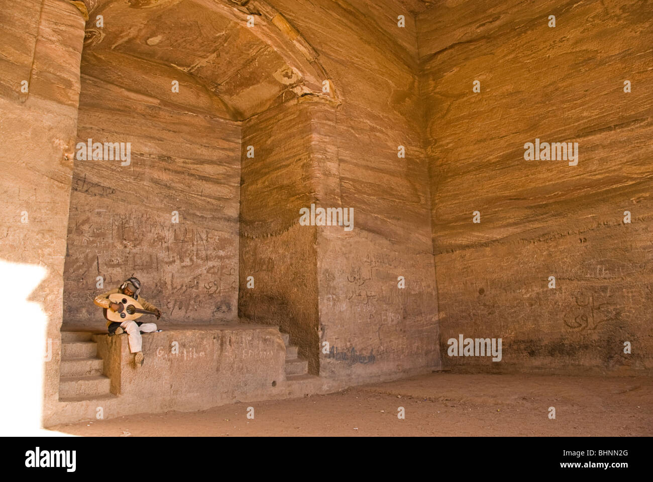 Beduin giocando una sorta di liuto all'interno del monastero di Petra, Giordania, Asia. Foto Stock