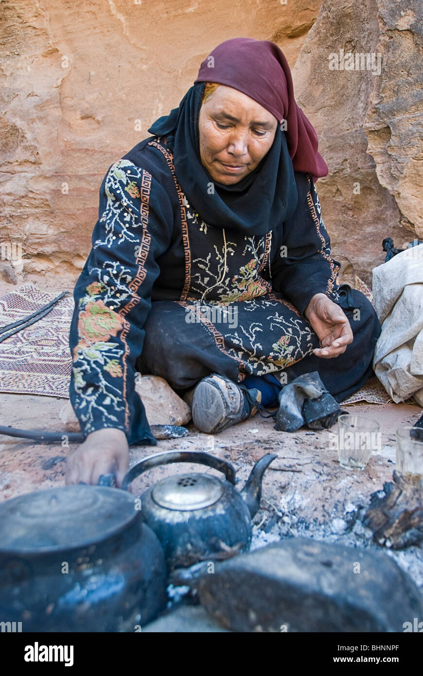 Donna Beduin tè nel fuoco, Petra, Giordania, Asia. Foto Stock