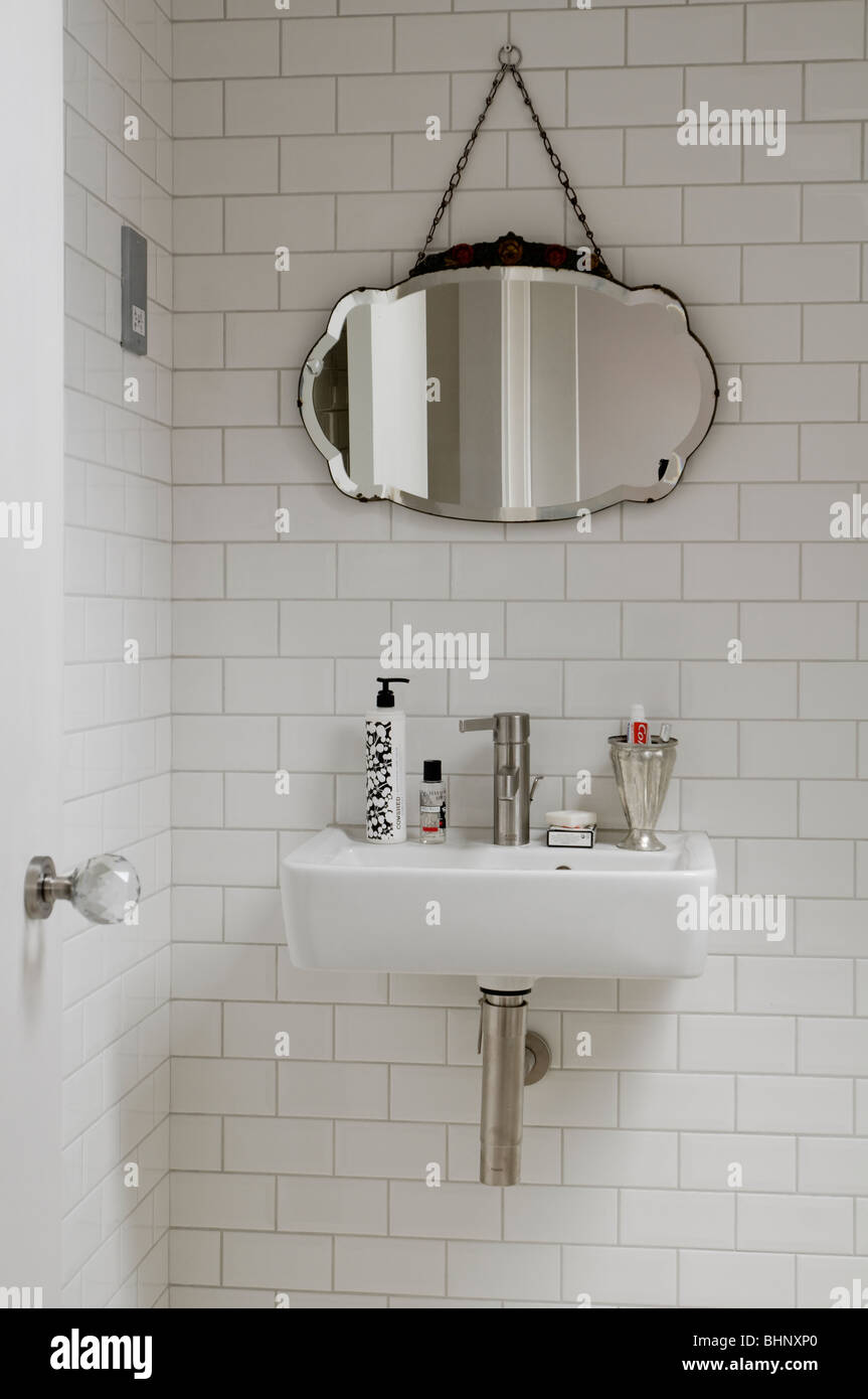 Lavandino e specchio antico in esecuzione moderna-bond bagno piastrellato  Foto stock - Alamy