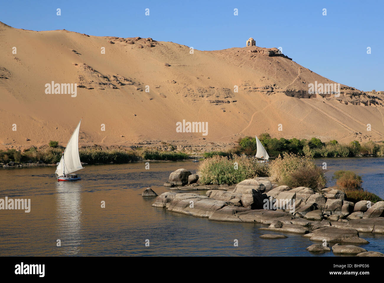 Due feluche navigano tra le tombe dei nobili e Kitchner's Island in Aswan, Egitto Foto Stock