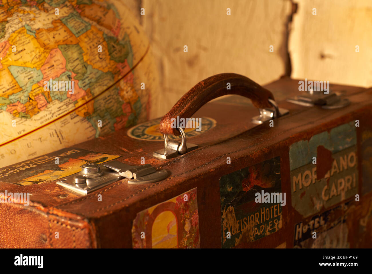 Vecchio marcato valigia di antiquariato accanto al globo mondo Foto Stock