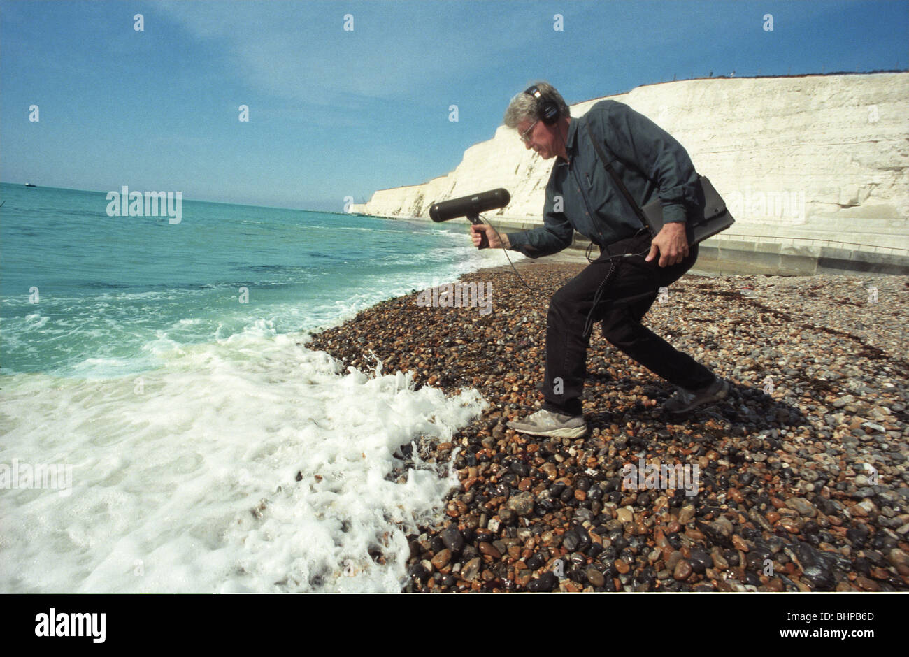 L'uomo la registrazione del suono del mare in inglese costa sud vicino a Eastbourne Foto Stock