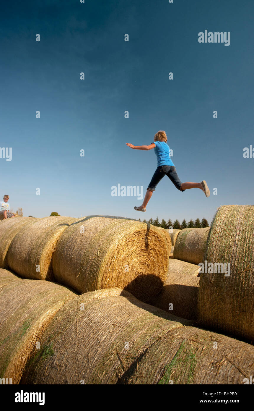 Ragazza di dodici anni salti tra le balle; Redvers, Saskatchewan, Canada Foto Stock