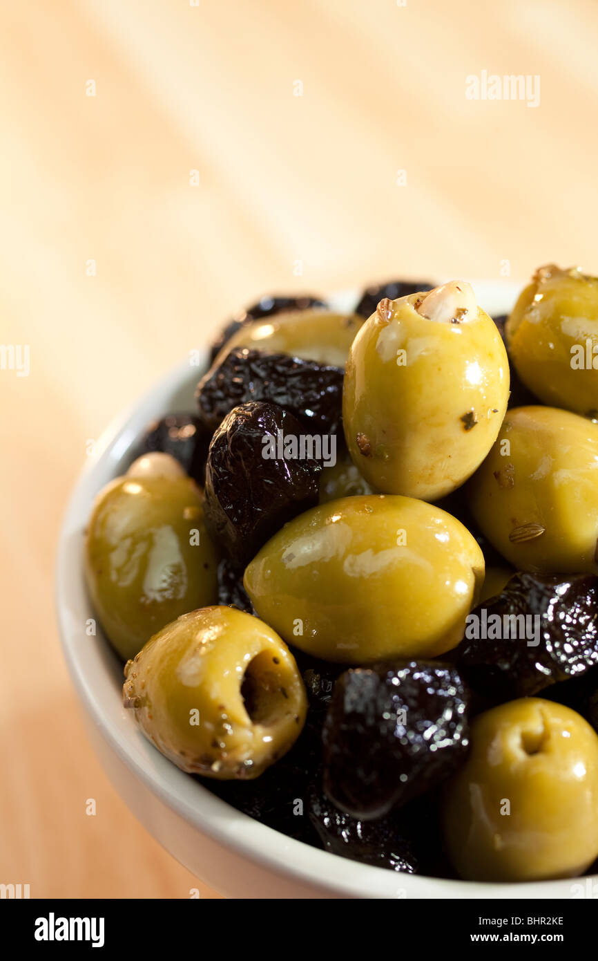 Close up macro fotografia di una ciotola di insaccati verde e nero di olive Italiane Foto Stock