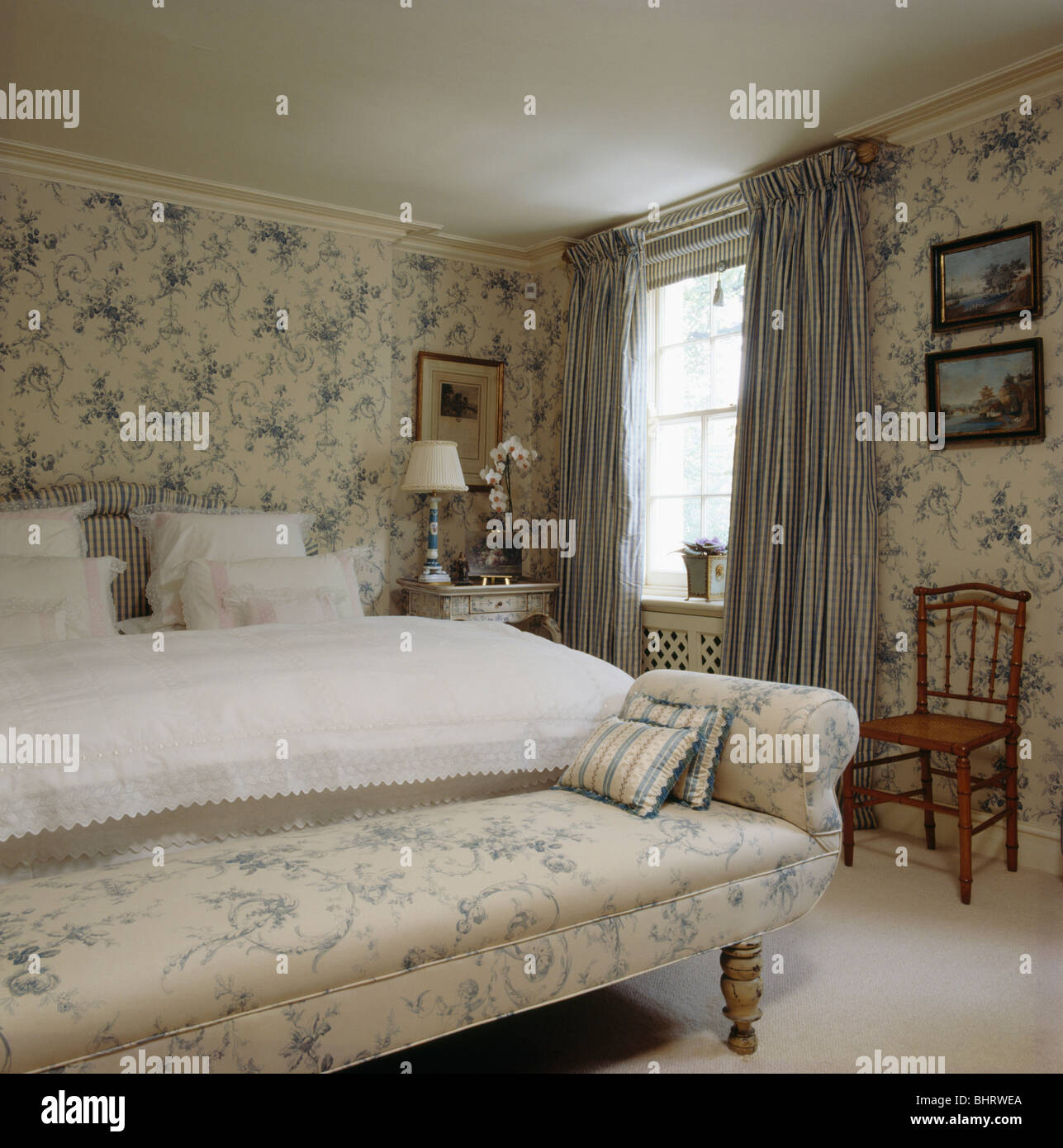 Blue+white floral chaise-longue e sfondo coordinato in camera da letto con  tende blu Foto stock - Alamy