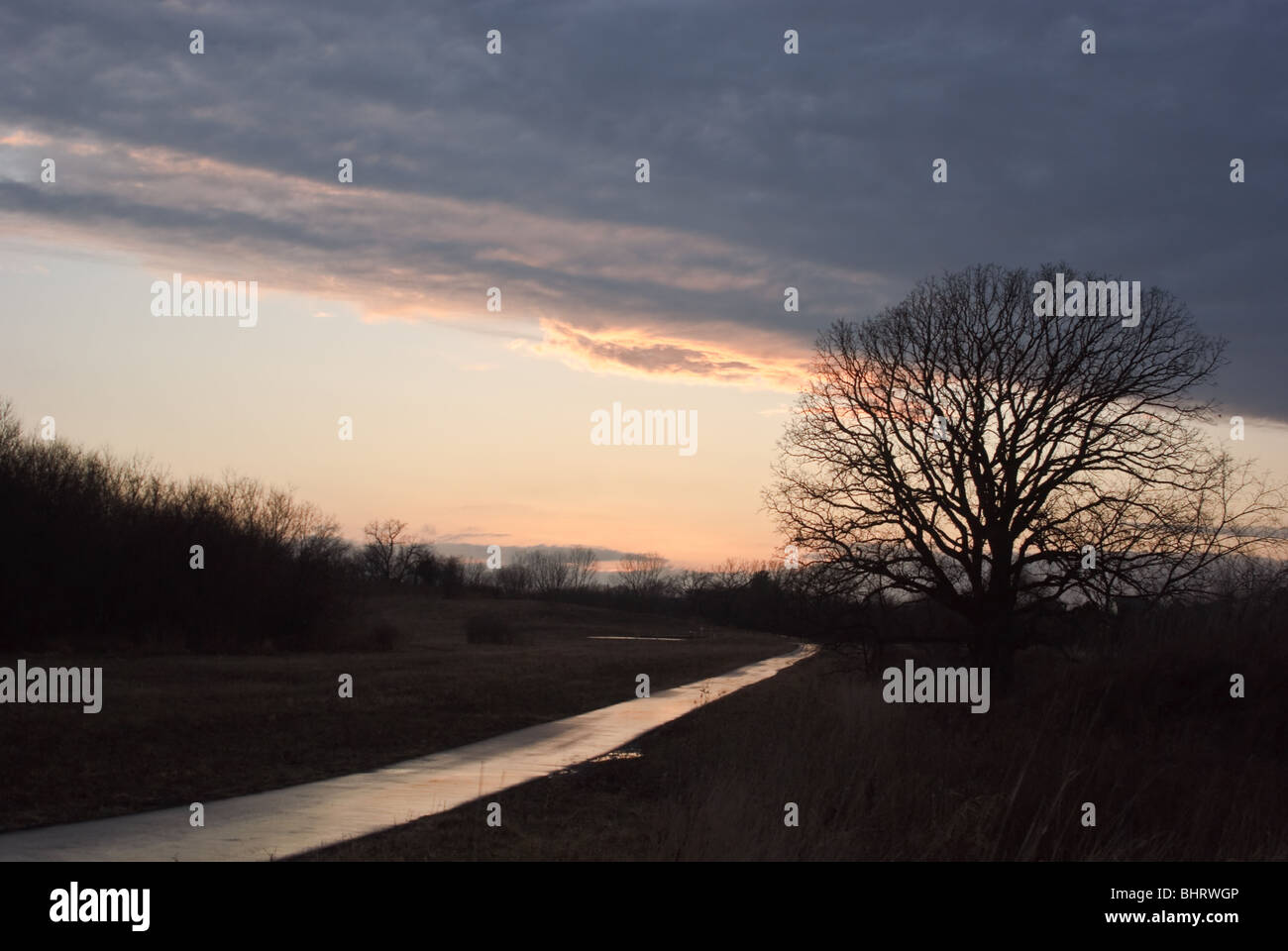 Il tramonto dopo una pioggia che risplende su di un percorso Foto Stock