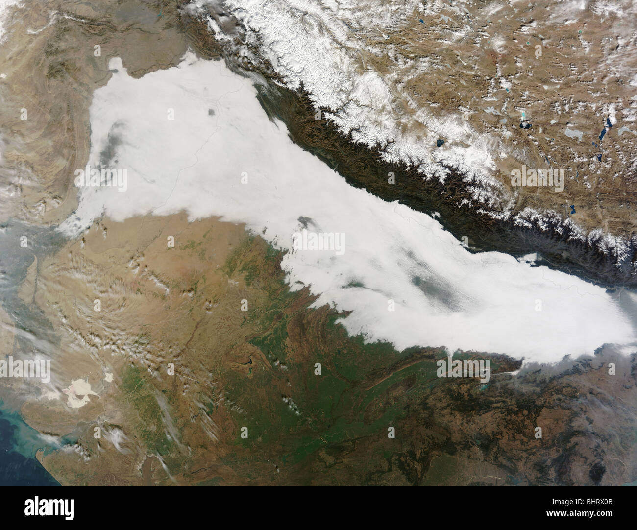 Una fitta coltre di nuvole basse copre le colline ai piedi delle montagne dell'Himalaya con qualche foschia visibile. Foto Stock