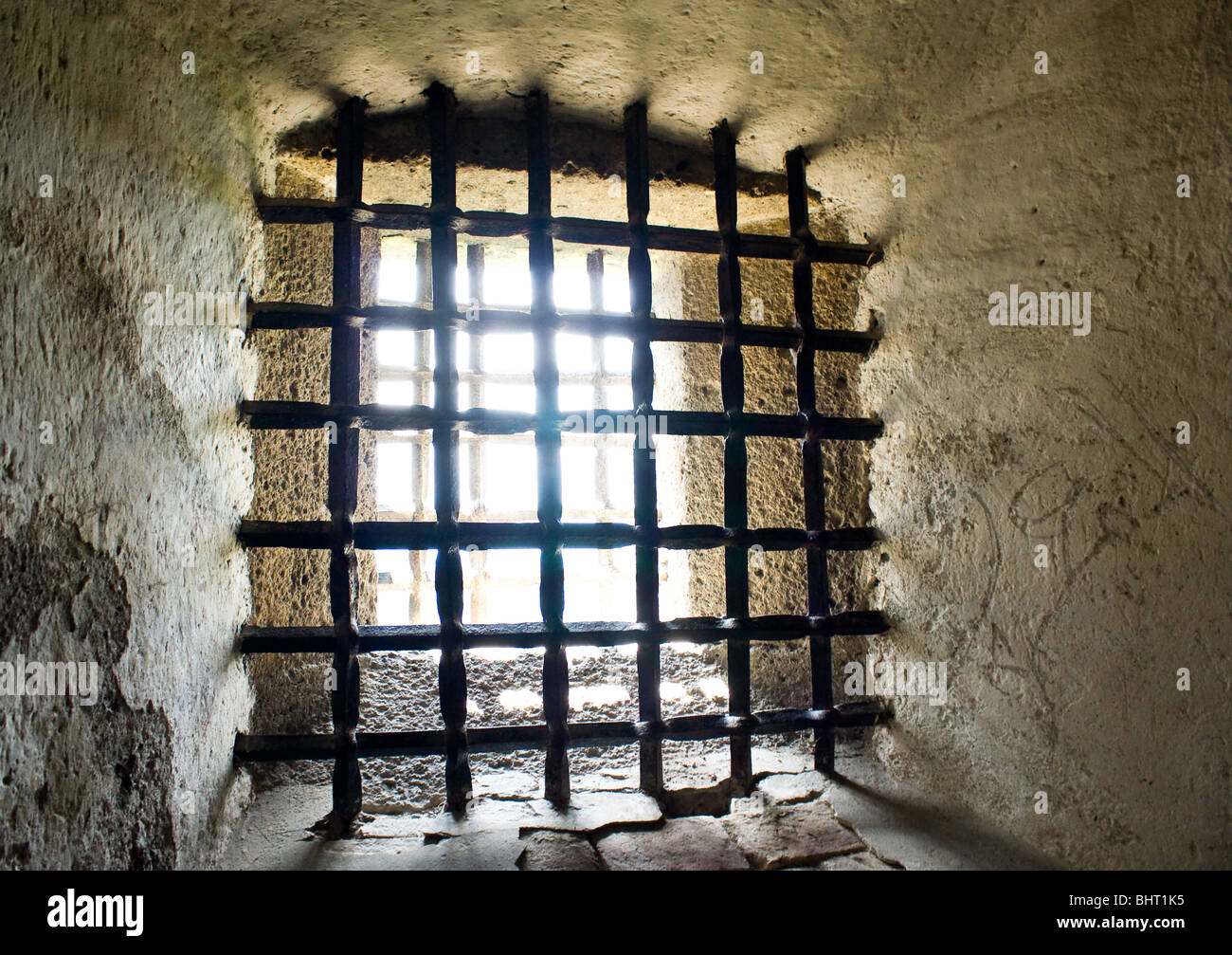 La luce del giorno si vede attraverso il ferro sbarre della prigione Foto Stock