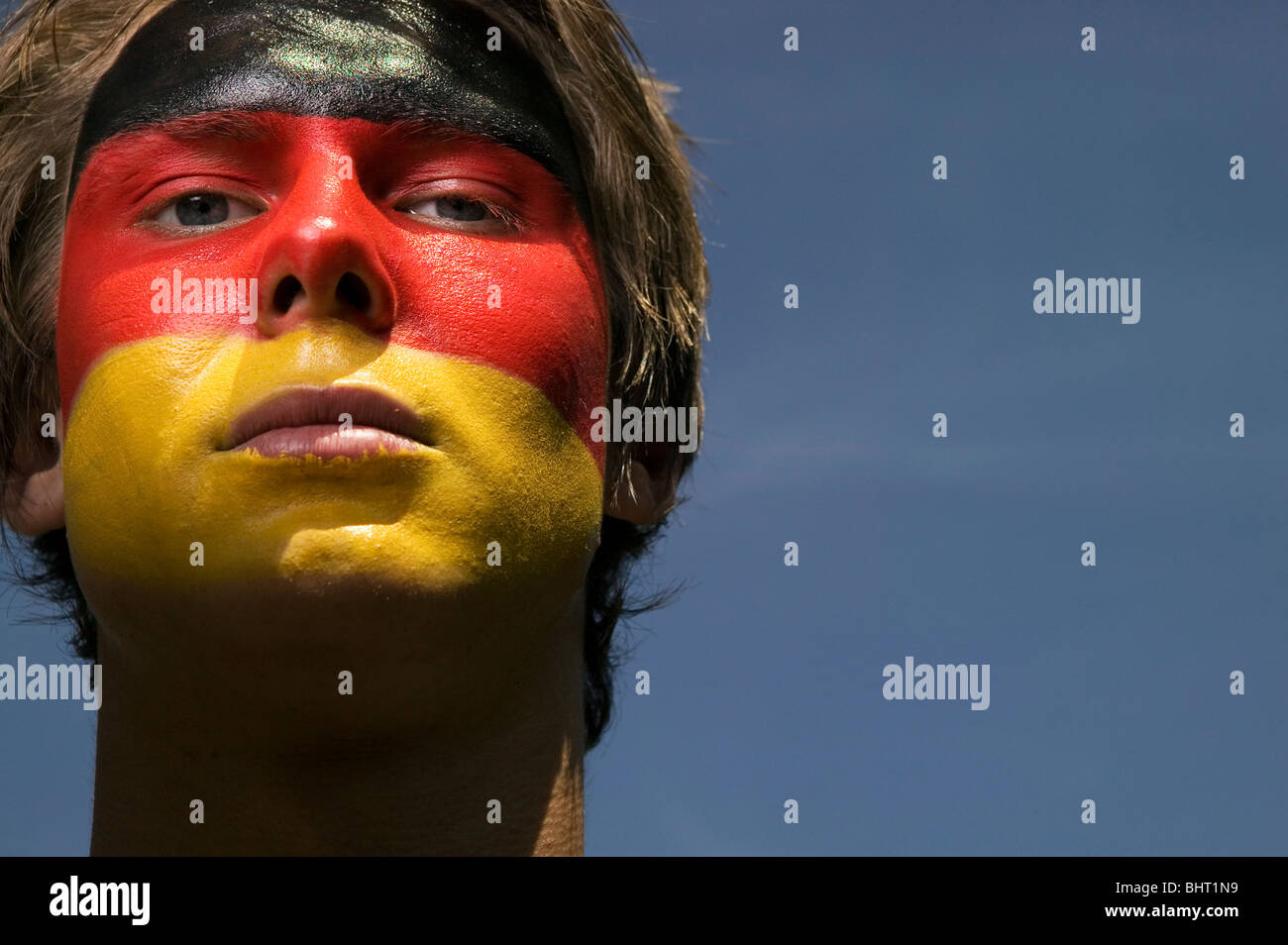 Un patriottico e grave alla ricerca di tedesco di calcio sostenitore con il tedesco della bandiera dipinta sul suo volto Foto Stock