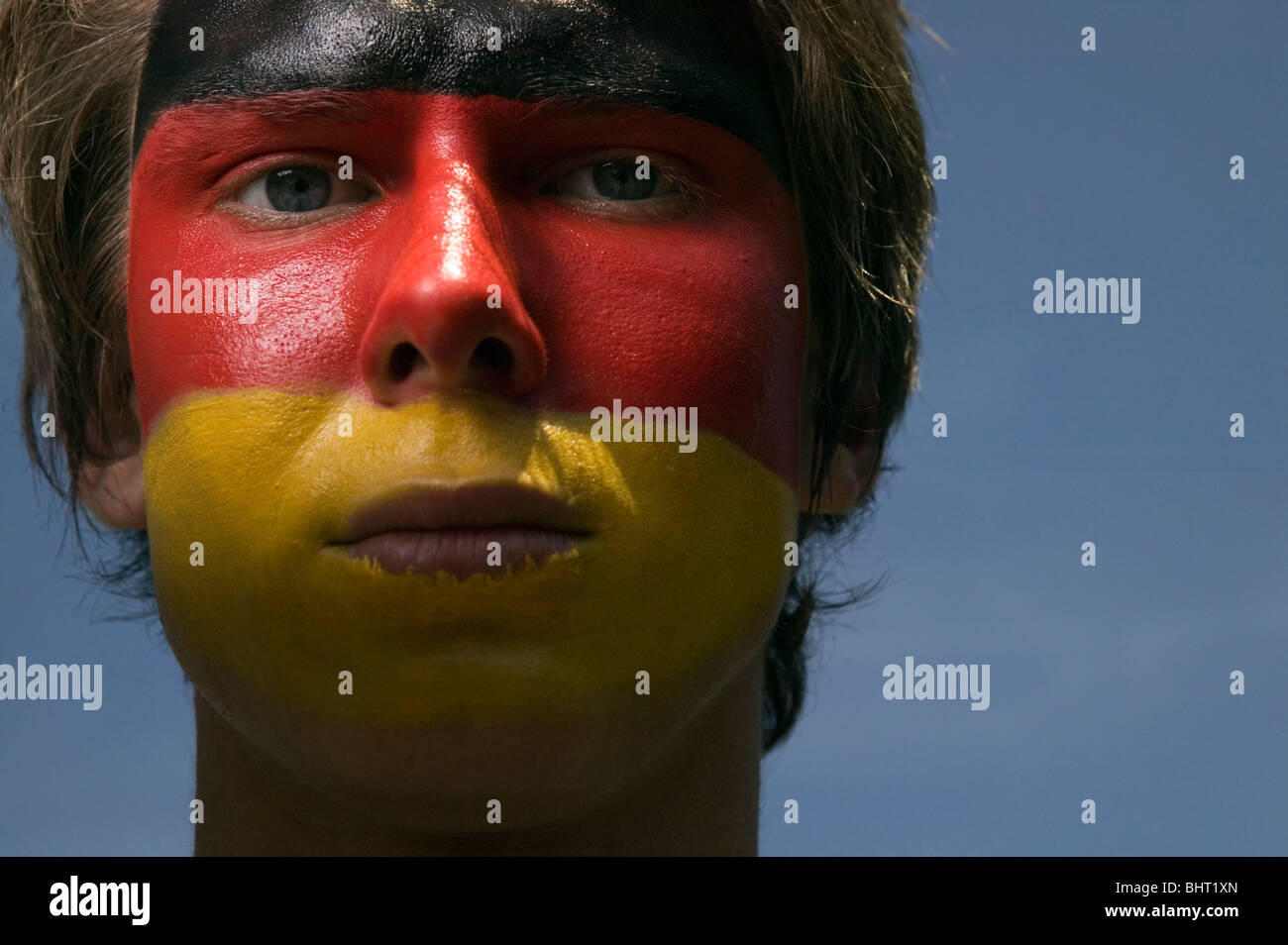 Un grave alla ricerca di tedesco di calcio sostenitore con il tedesco della bandiera dipinta sul suo volto Foto Stock