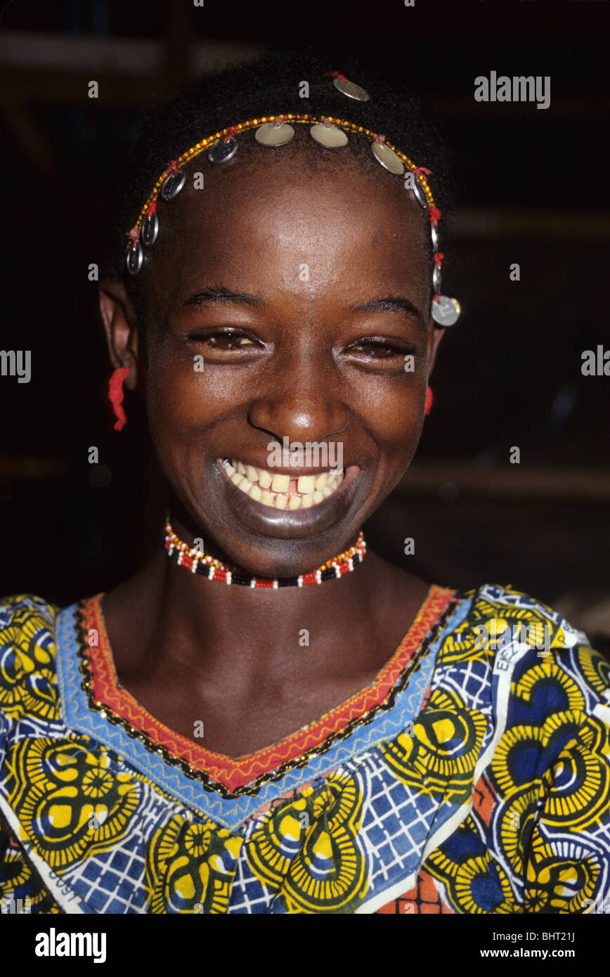 Tortiya, Costa d'Avorio, Costa d'Avorio, in Africa occidentale. Fulani ragazza sorridente. Headwear decorate con monete. Foto Stock