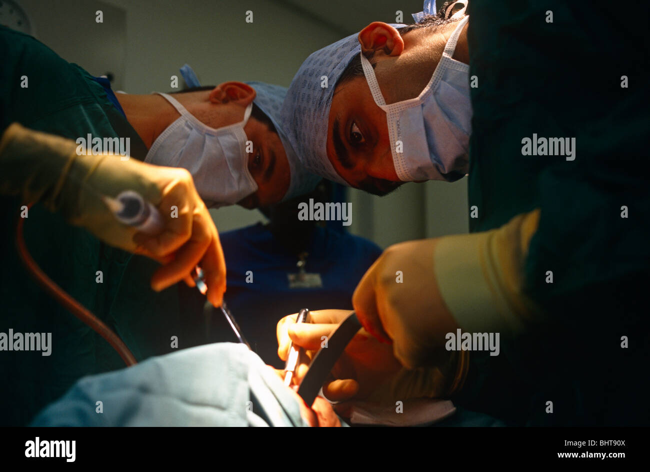 Con grande cura, due chirurghi lavorare intensamente durante un open-cuore procedura presso la struttura sanitaria privata International Hospital. Foto Stock