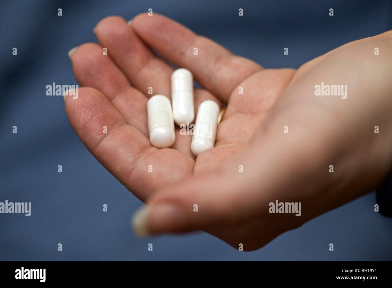 Capsule contenenti polvere bianca nella donna la mano. Foto Stock