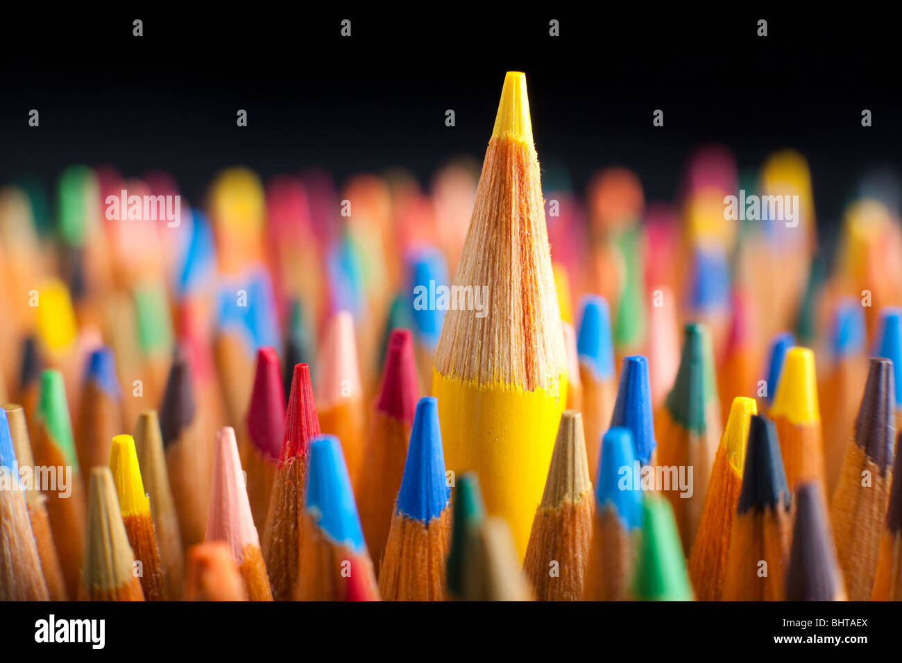 Matite di colore che rappresenta il concetto di levarsi in piedi fuori dalla folla Foto Stock