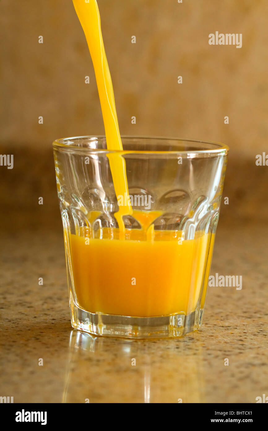 Versando un bicchiere di succo d'arancia fresco Foto Stock