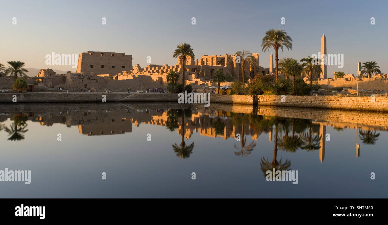 Tempio di Karnak riflettente nel lago sacro al tramonto a Luxor, Egitto. Foto Stock
