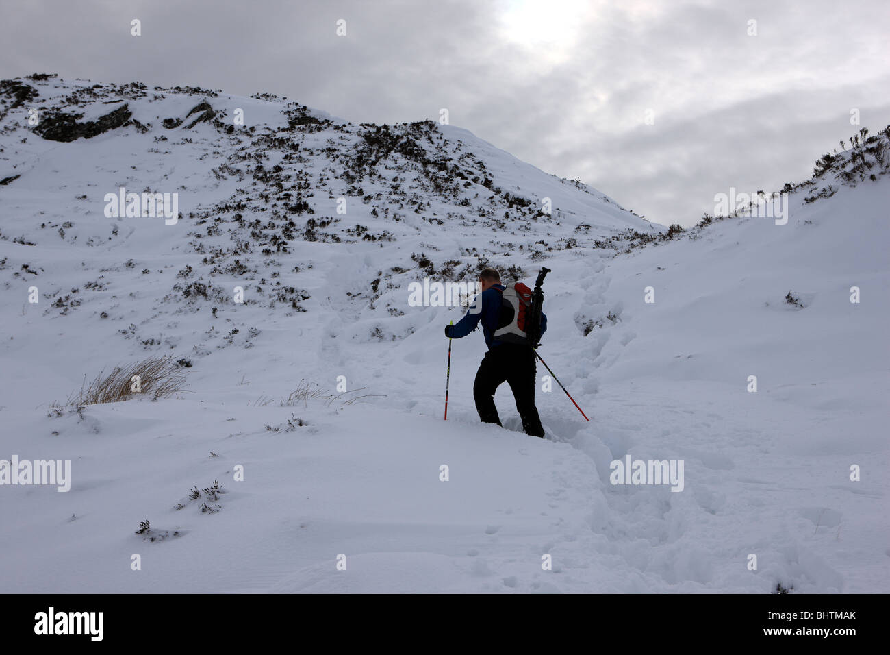 Walker nella neve profonda sulla salita finale al vertice di ben un'an nel Trossachs Foto Stock