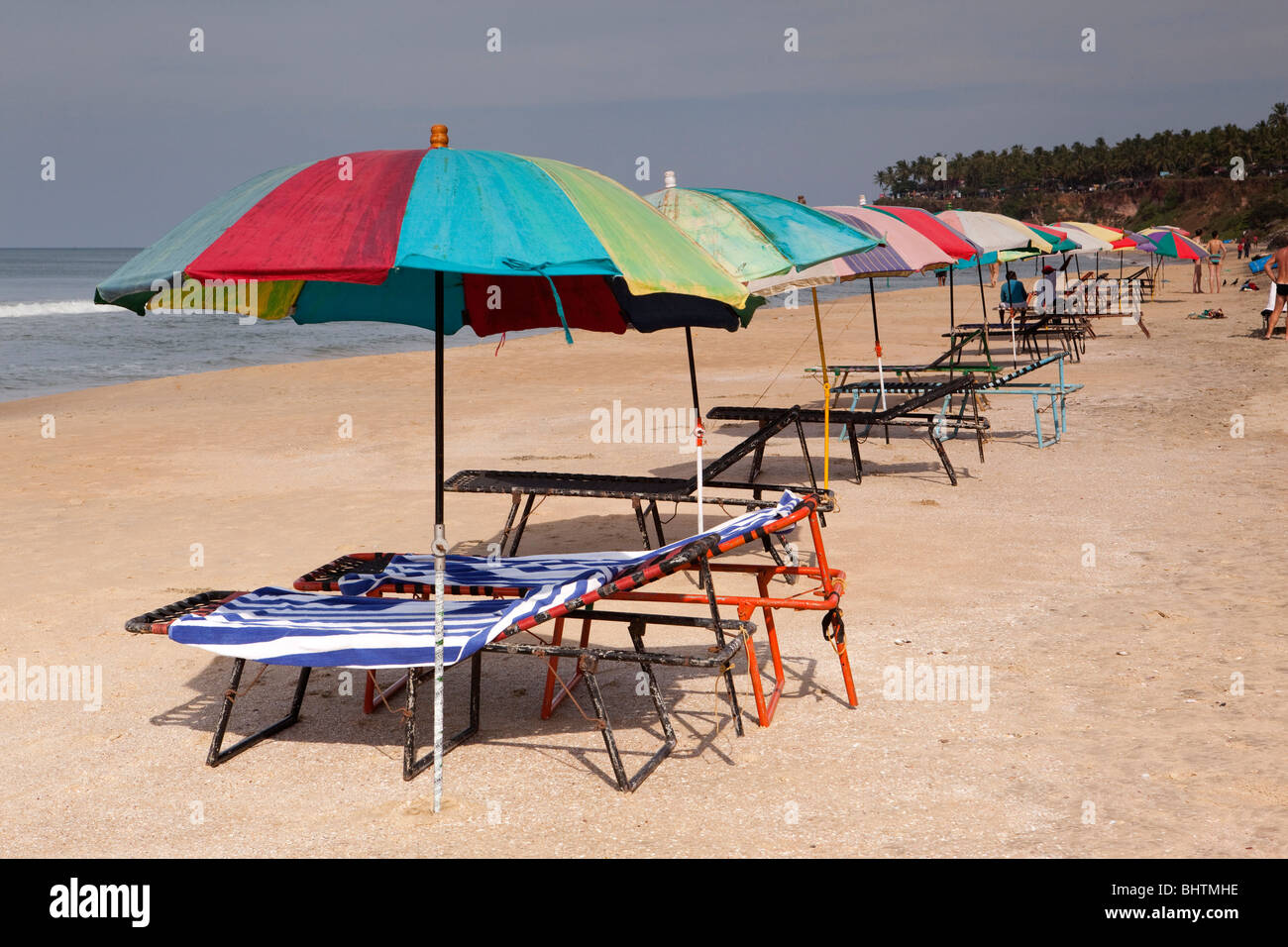 India Kerala, Varkala Beach, colorati ombrelloni e sdraio vuota Foto Stock