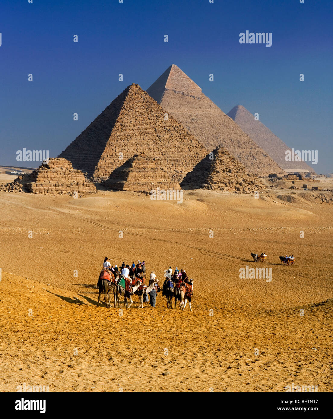 I turisti di cammelli di equitazione presso le Piramidi di Giza, Cairo, Egitto. Foto Stock