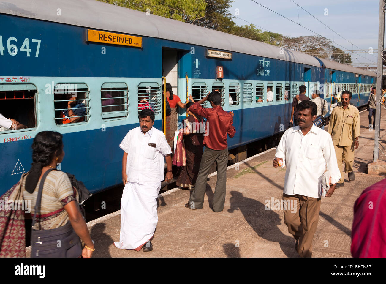 India Kerala, Quilon giunzione stazione ferroviaria, i passeggeri sulla piattaforma di salire a bordo treno Foto Stock