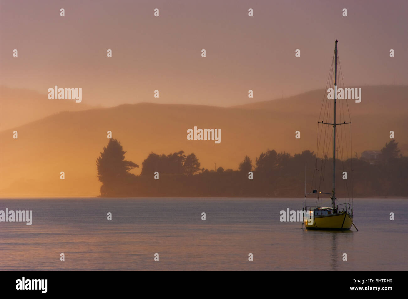 Una solitaria yacht al suo posto barca in mattina presto la luce in corrispondenza di Waikawa Harbour nel distretto di Catlins, Southaland, Nuova Zelanda Foto Stock