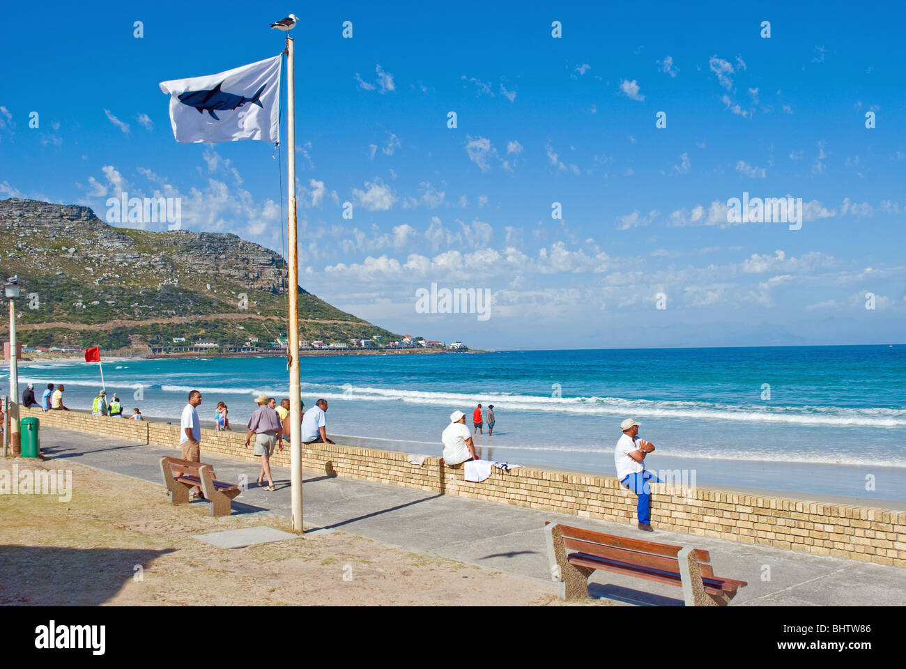 Un avviso di squalo bandiera sventola su False Bay beach a Fishhoek e traino del capo, in Sud Africa per i bagnanti di avvertimento di rimanere fuori dall'acqua. Foto Stock