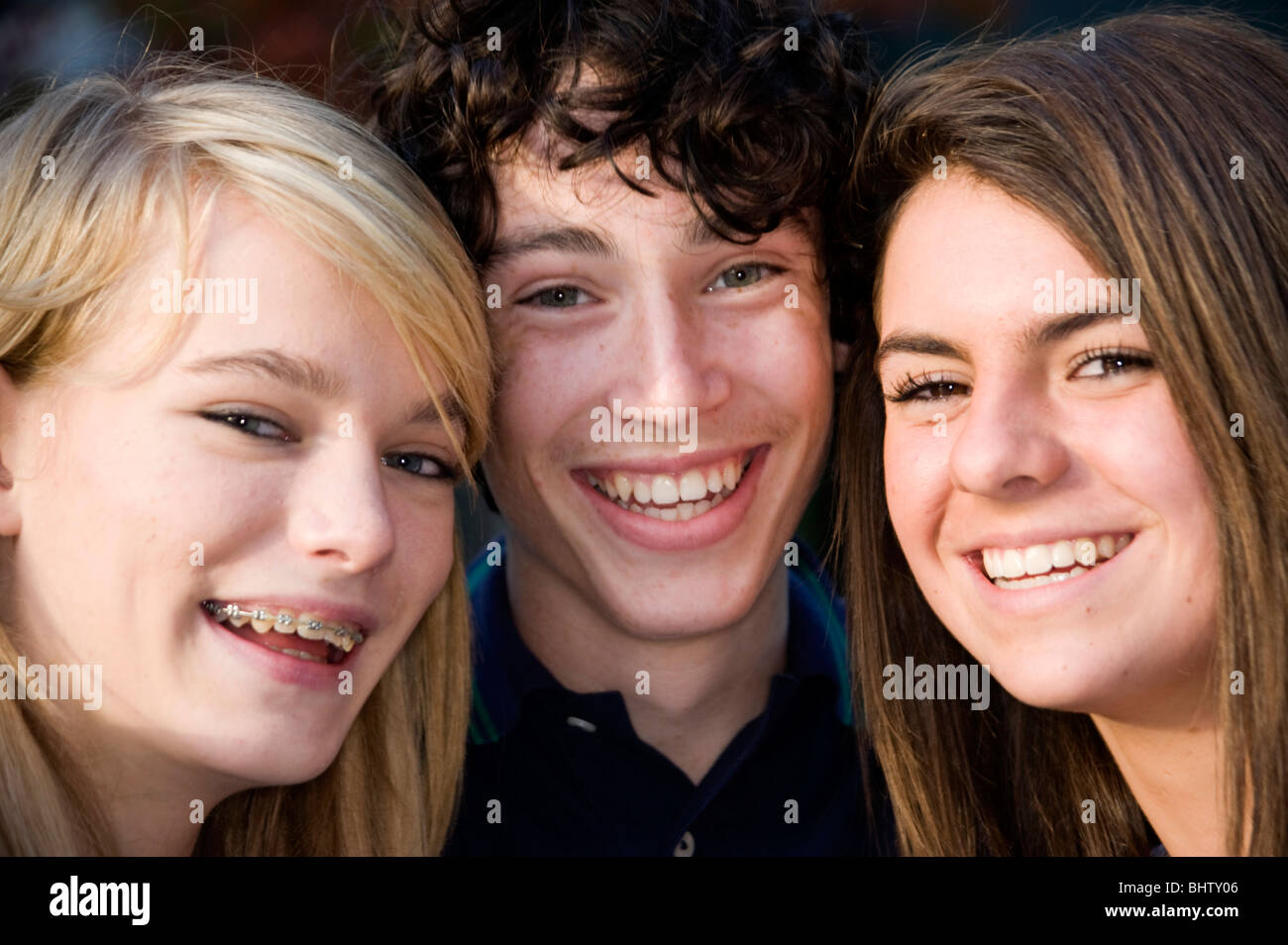 2 ragazze adolescenti e un ragazzo adolescente con le loro teste insieme guardando nella telecamera Foto Stock
