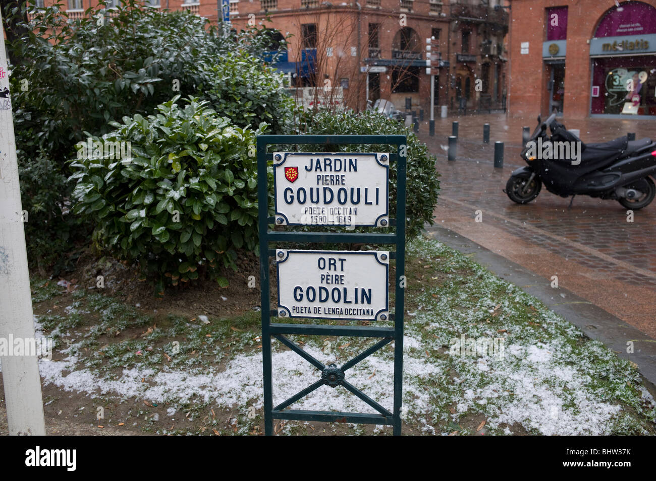 Segni bilingue presso il giardino di Pierre Goudouli, Occitano poeta, a Toulouse Haute Garonne, Occitanie, Francia sotto la pioggia in inverno Foto Stock