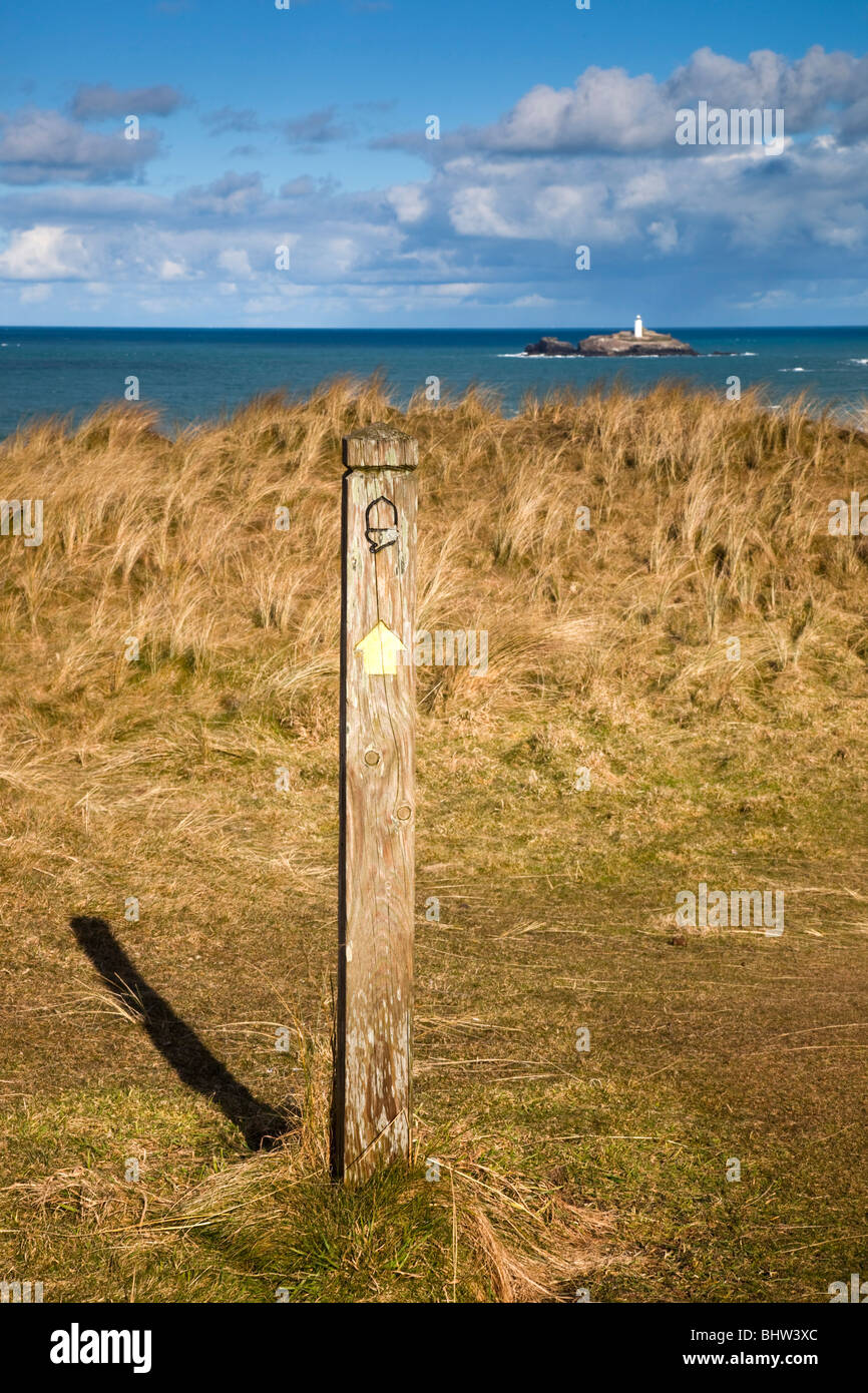 Gwithian Towans; cercando di Godrevy lighthouse; sentiero costiero marcatore in primo piano; Cornovaglia Foto Stock