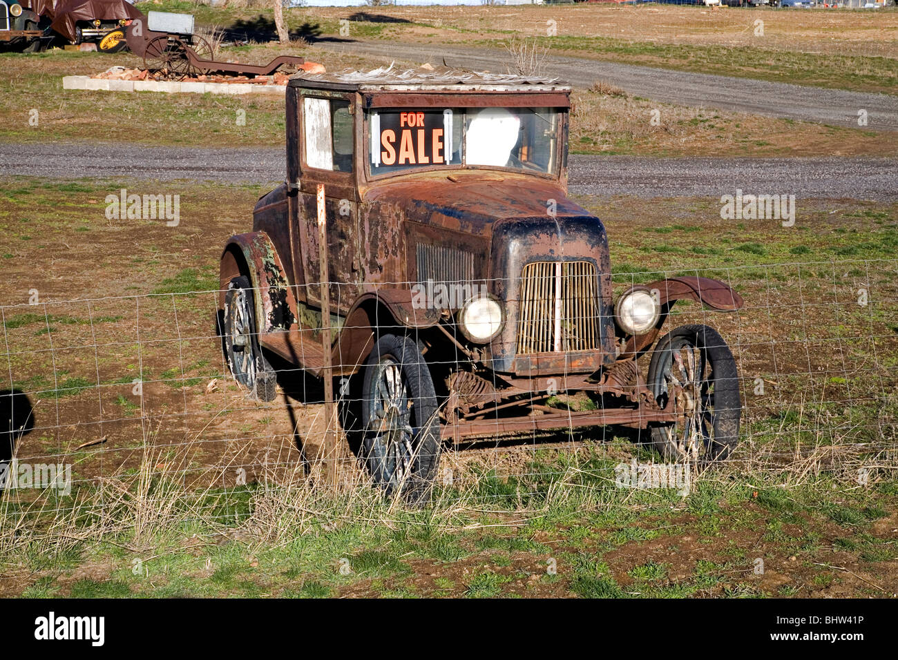 Una per la vendita segno su un arrugginito antique classica vecchia auto in un campo a Madras, Oregon Foto Stock