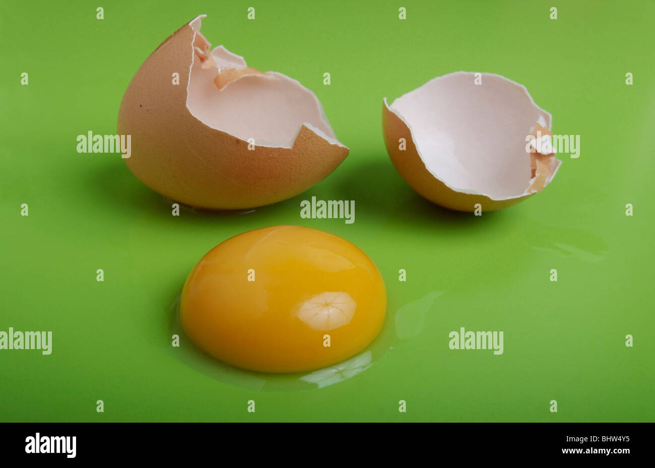 Solo tuorlo d'uovo con shell su sfondo verde Foto Stock