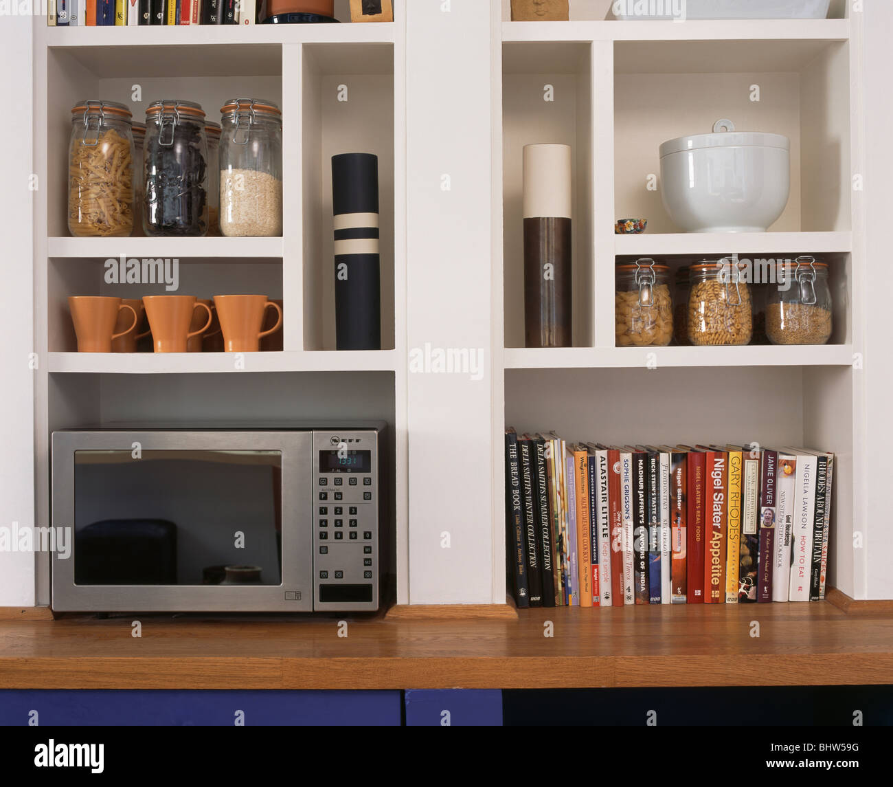 Close-up di forno a microonde e di vetro vasetti di storage con i libri sul  cubo bianco Ripiani Foto stock - Alamy