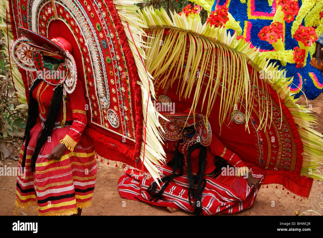 Theyyam forme d'arte appena seduto e rilassante per un po' durante un tempio indù Festival occasione.Scena Theyyattam Kerala, India Foto Stock