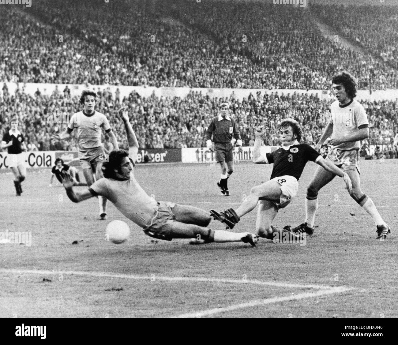 Il Brasile v Scozia durante la Coppa del Mondo di Calcio 1974 Denny Dalglish (n. 8) in azione. calciare la palla caduta partita di calcio in giugno Foto Stock