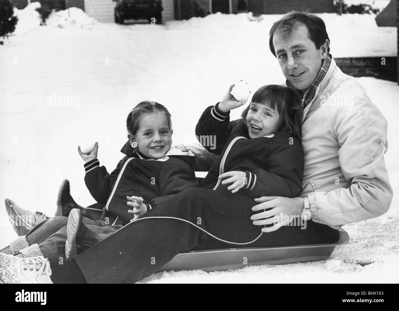 Newcastle United player Mick Martin gode di una macchia di slittare con le sue due figlie Maeve invecchiato, 4, e Siobhan dai 6 anni in casa loro a Whickham 26 dicembre 1981. Mai mente il famoso brasiliano Zico che ha recitato nel 1978 World Cup, Regno aveva la propria Zico nel centrocampo - Dubliner Mick Martin, raffigurato nella neve con le sue due figlie. Mick è stato soprannominato Zico dopo la sua guida corre dal centrocampo per il Regno. Foto Stock