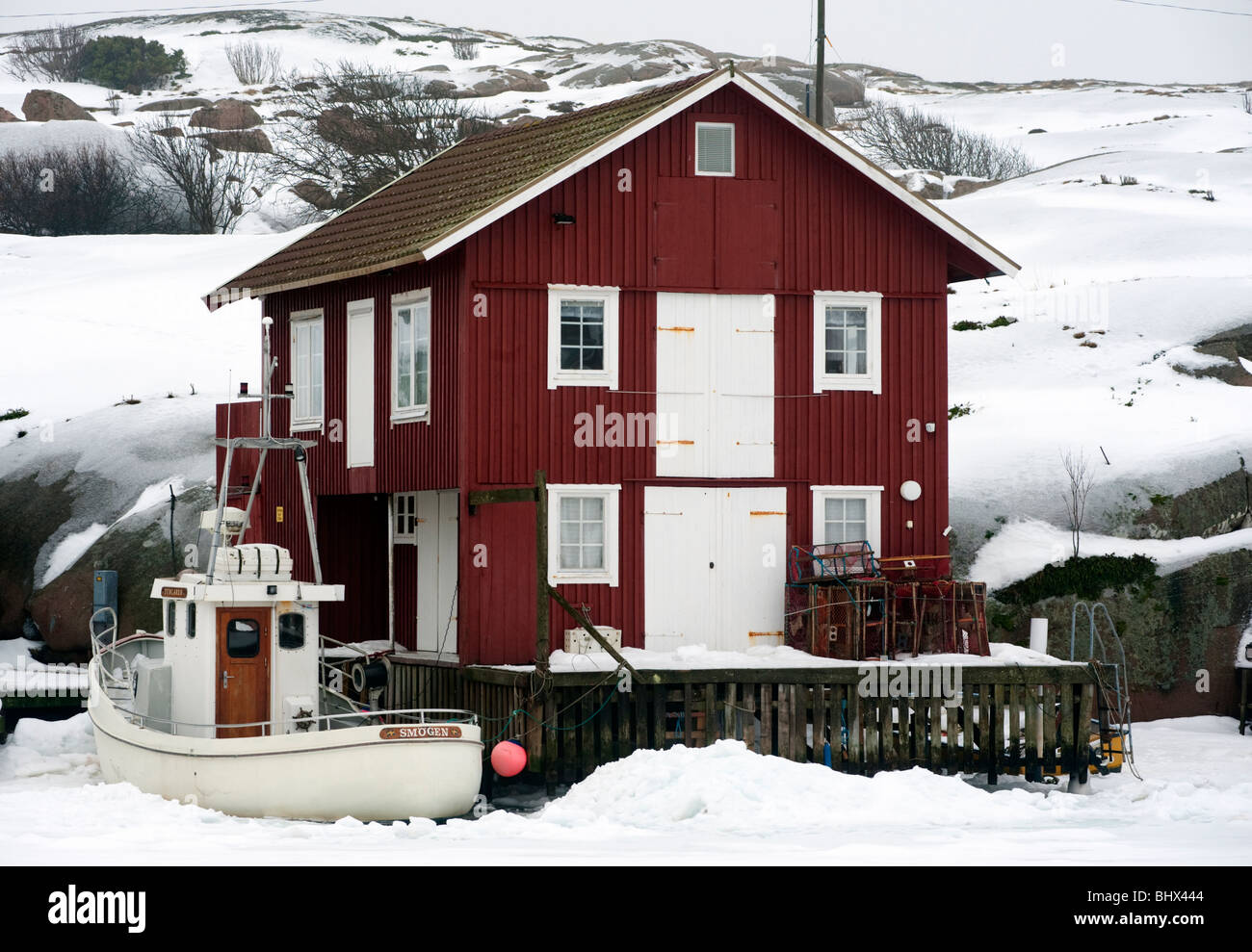Smogen; Barca e red boathouse nel tradizionale villaggio di pescatori Smogen durante l inverno dopo la neve sulla costa di Bohuslan in Svezia Foto Stock