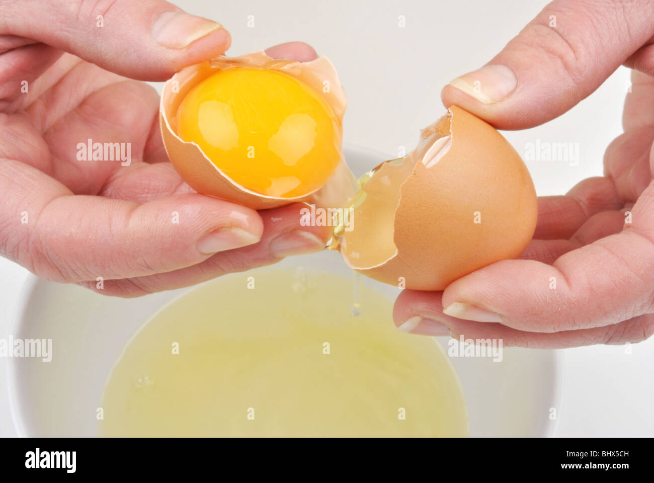 Aprire un uovo di organico per separare il tuorlo d'uovo Foto Stock