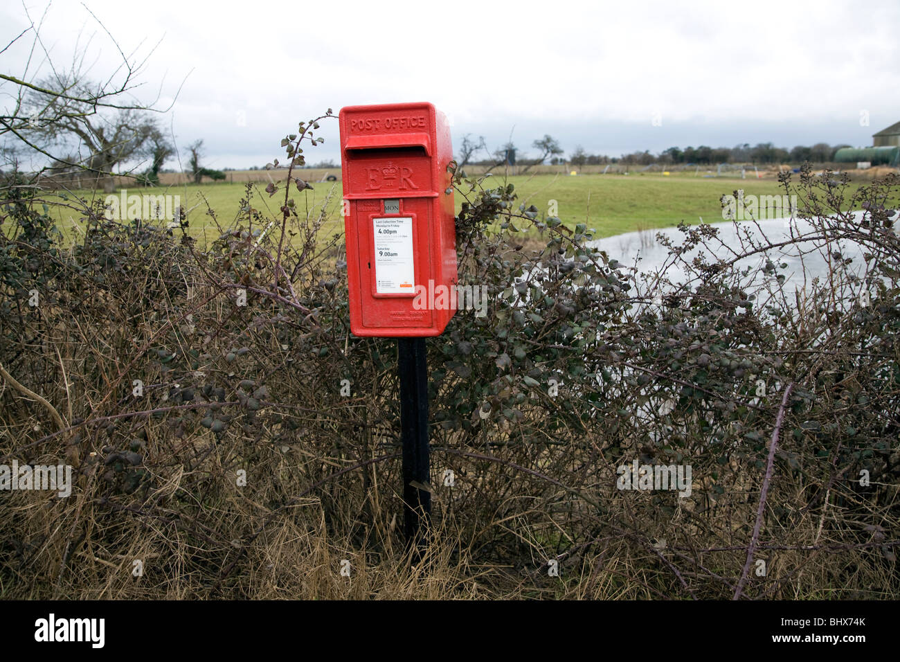 Rosso casella postale sul pilastro solo nella campagna del Suffolk Bawdsey Inghilterra Foto Stock